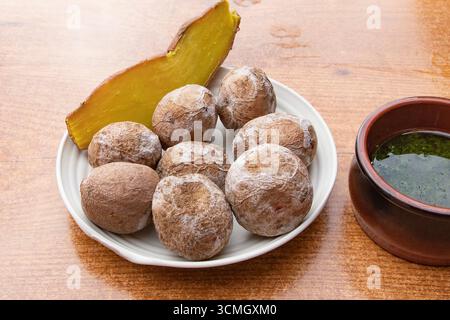Tradizionale arrugada di patate rughe delle Canarie servito con salsa di mojo verde e fetta di zucca. Cucina tipica delle Isole Canarie, spagnola Foto Stock