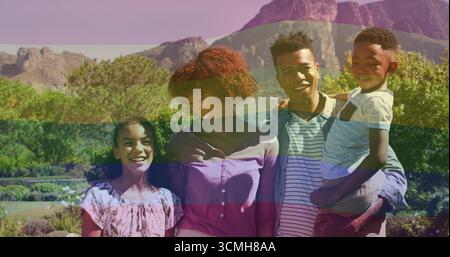 Famiglia di quattro persone con abiti primaverili in un giardino paesaggistico, con arbusti fioriti e montagne Foto Stock