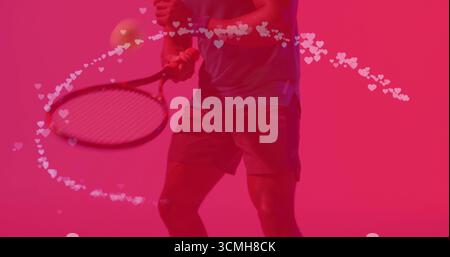Atleta medio adulto che colpisce il dorso a due mani in un set rosa con arco a forma di cuore intorno alla testa della racchetta Foto Stock