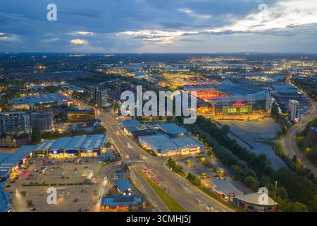 Vista aerea al crepuscolo di Old Trafford Manchester e White City Retail Park con strade luminose e sentieri per il traffico. Foto Stock