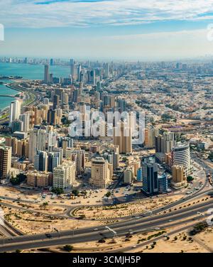 Vista aerea dello skyline di Kuwait City con moderni grattacieli, strade costiere e paesaggio urbano del Kuwait Foto Stock