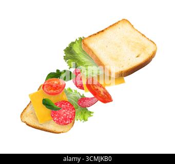 Fette di pane tostato e ingredienti da sandwich che volano in aria su sfondo bianco Foto Stock