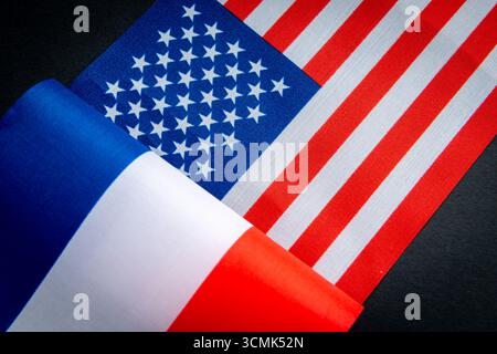 La bandiera nazionale francese, insieme alla bandiera degli Stati Uniti, è isolata sul nero. Un concetto di relazioni tra Francia e Stati Uniti. Foto Stock