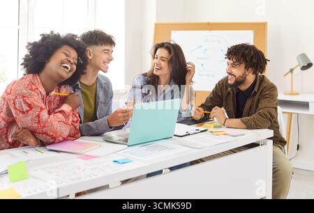 Ufficio sorridente colleghi diversi seduti si riuniscono nella sala riunioni alla scrivania con il computer portatile per fare brainstorming Foto Stock