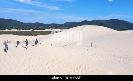 Vista aerea delle dune di Joaquina Beach a Florianópolis, Santa Catarina. Persone che navigano sulla sabbia, sandboard, sport, dune, restinga. Foto Stock