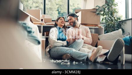 Conversazione, ridere e pianificare con la coppia in una nuova casa per investimenti immobiliari o immobiliari. Casa divertente, traslocante e visione con persone felici Foto Stock