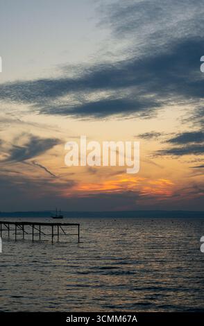 Tramonto sul lago balaton Siófok in Ungheria molo di legno verticale Foto Stock