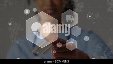 Donna in scrub con stetoscopio che regge blister e icone esagonali fluttuanti in clinica Foto Stock