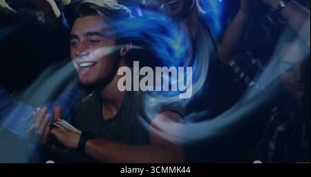 Ballerino che indossa T-shirt verde oliva e orologio da polso scuro sulla pista da ballo del club, con sentieri leggeri Foto Stock