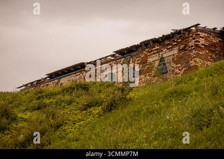 Vecchia facciata del garage in mattoni rossi abbandonati Foto Stock