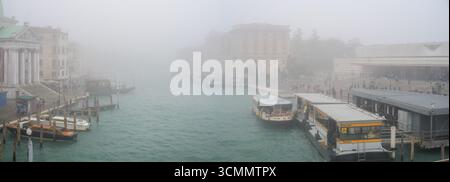 Il Canal grande di Venezia è avvolto dalla nebbia, con San Simeone piccolo e la fermata del vaporetto che scompaiono nella nebbia in una giornata tranquilla. Foto Stock