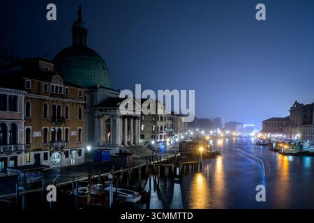 Il Canal grande brilla sotto il cielo notturno, mostrando San Simeon piccolo illuminato in mezzo all'acqua tranquilla e al delicato movimento delle barche. Foto Stock