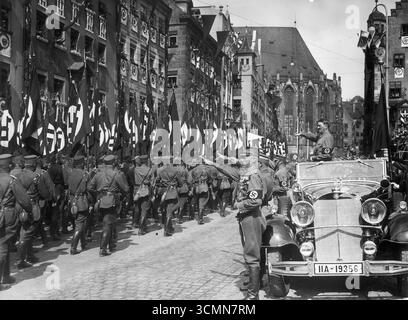 Il cancelliere Adolf Hitler riceve la parata da una Mercedes in Piazza Hitler. Le protezioni dei colori sono visibili, 1935 Foto Stock