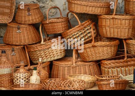 Una varietà di cesti rustici e tessuti in vendita in un negozio, mercato tradizionale Foto Stock