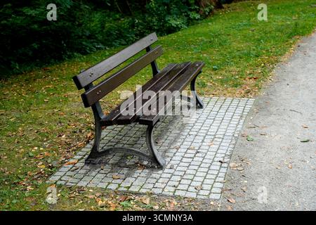 Panca di legno in un parco della città Foto Stock