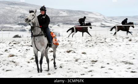I cavalli da corsa portano a Middleham Moor, nel North Yorkshire, sulle galoppine da addestramento coperte di neve, per un'incredibile scena invernale Foto Stock