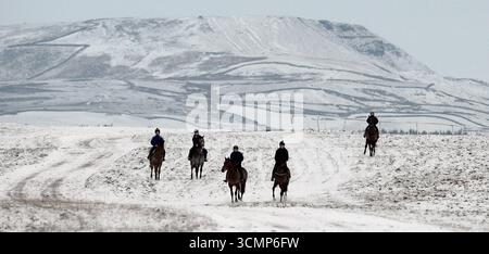 I cavalli da corsa portano a Middleham Moor, nel North Yorkshire, sulle galoppine da addestramento coperte di neve, per un'incredibile scena invernale Foto Stock