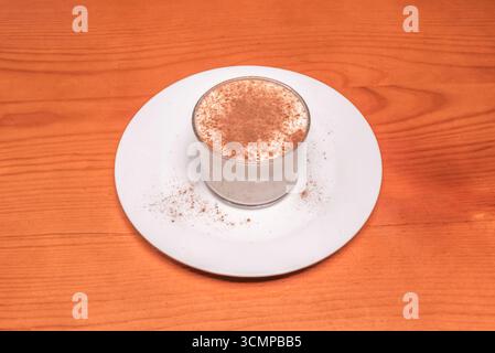 Budino di riso al cocco con latte condensato e fiocchi di cocco tostati, guarniti con fette di banana caramellate e menta fresca Foto Stock