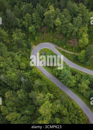 Curva stretta in una strada circondata da fitta foresta, Foresta Nera, Seebach, Germania Foto Stock