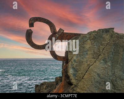 Il pettine della Scultura del vento al tramonto - la famosa scultura il pettine del vento di Eduardo Chillida sulla costa di San Sebastián, Spagna al sole Foto Stock