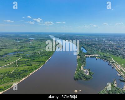 Un'ampia prospettiva aerea che mostra il fiume Oka che si snoda attraverso il verde paesaggio con il paesaggio urbano di Murom visibile sulla riva destra. Foto Stock