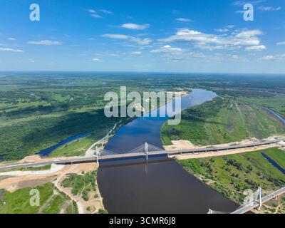 Vista ad alto angolo del moderno Murom Bridge con il suo design strallato che attraversa l'ampio fiume Oka sotto un cielo limpido. Foto Stock