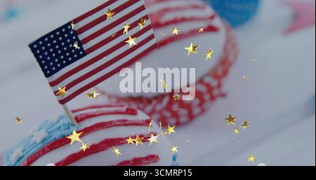 Cupcake seduto su un tavolo bianco, con selezione della bandiera americana, cupcake a pois e coriandoli d'oro Foto Stock