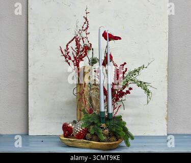 Festività natalizie con cardinali rossi, candele, rami di pino, bacche e ornamenti. Vacanza rustica che crea un ambiente caldo e commerciale Foto Stock