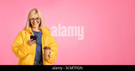 Stile di vita e tecnologia mobile. Felice signora in giacca gialla tex Foto Stock