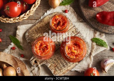 Tre vasetti di pomodoro fatto in casa e peperoni dolci (pasta di verdure in stile ajvar, chutney o bruschetta), vista dall'alto Foto Stock
