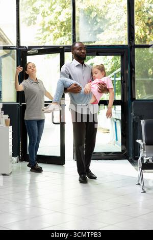 I membri della famiglia preoccupati reagiscono alla figlia inconscia in ambiente ospedaliero, affidandosi a personale sanitario professionale per cure di crisi e cure urgenti per il salvataggio della vita. Emergenza. Foto Stock