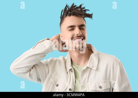 Giovane uomo con dreadlock su sfondo blu Foto Stock