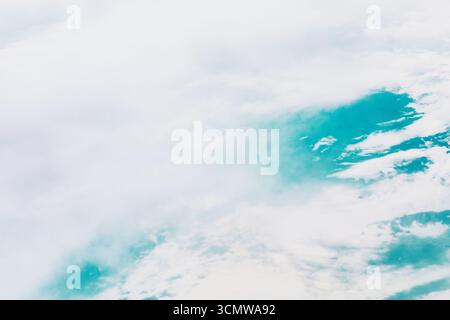 Nuvole piene di neve dall'alto del mare. Prospettiva dall'alto, catturando l'equilibrio tra le nuvole e l'oceano blu Foto Stock