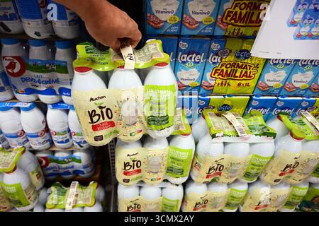 Il cliente preleva il latte Bio da sei confezioni al supermercato Foto Stock