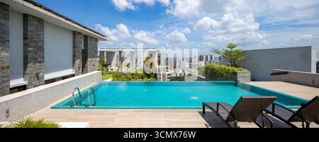 Piscina sul tetto con vista panoramica sulla città, che offre un soggiorno all'aperto di lusso e un rifugio perfetto. Foto Stock