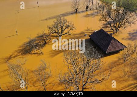 Vista aerea della casa del villaggio che affonda nel mezzo del laghetto di decantazione della miniera di acidi tossici. Geamana, Rosia Montana, Romania Foto Stock