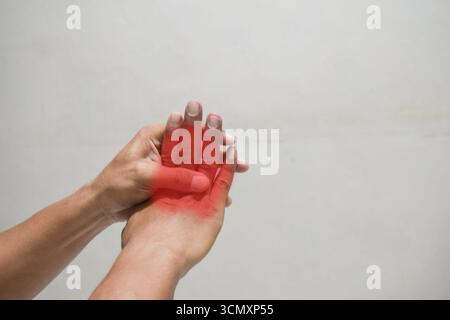 mano di uomo che soffre di dolore alla mano su sfondo beige. concetto di assistenza sanitaria Foto Stock