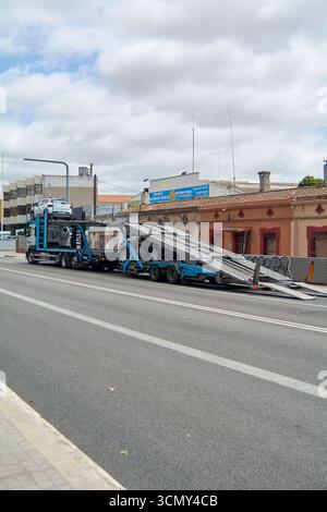Viladecans, Barcellona - 17 settembre 2025: Un camion per il trasporto di veicoli circola su una strada della città. L'immagine acquisisce il trasporto dell'automo Foto Stock