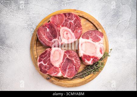 Ossobuco di vitello crudo in marmo, perfetta carne di gambo tagliata a croce per ricette tradizionali italiane e gustose cene di famiglia. sfondo bianco. v superiore Foto Stock