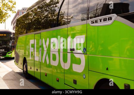Berlino, Germania - 1 settembre 2025: Gli autobus parcheggiano presso un terminal Flixbus di Berlino, pronti per i passeggeri. Il sole splende brillantemente, mettendo in risalto la vibra Foto Stock
