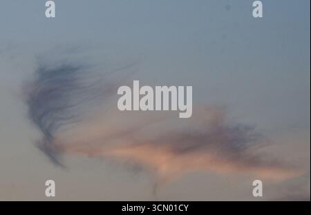 Serena vista del cielo durante il tramonto, piena di colori tenui, sfumature delicate e magiche tonalità di luce del giorno che svanisce. Foto Stock