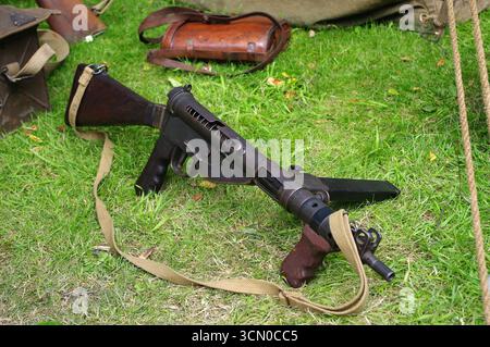 Una pistola Sten britannica della seconda guerra mondiale con cinghia di tela stesa sull'erba. Foto Stock
