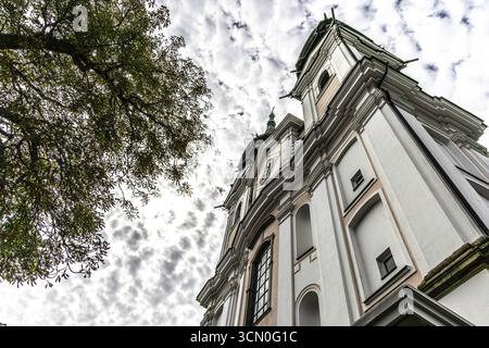 Impressionante vista di una chiesa barocca dal basso con sagoma di alberi, la basilica di pellegrinaggio di Poestlingsbergkirche Sieben Schmerzen Maria Linz Au superiore Foto Stock