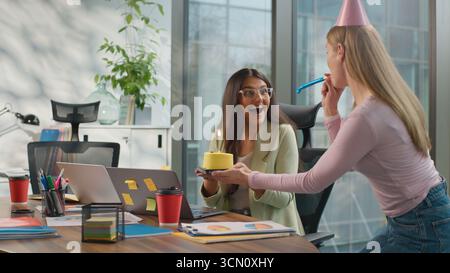 Festeggiamenti di compleanno ufficio aziendale stupito felice imprenditrice indiana donna araba computer portatile occupato diversità amichevole colleghi di lavoro sorprendente Foto Stock