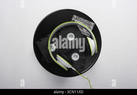 Supporti retro. Cuffie stereo, videocassette, dischi in vinile, audiocassette su sfondo bianco. Foto Stock