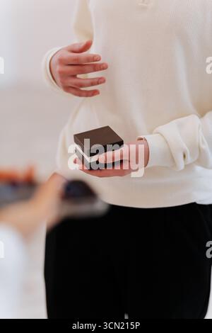 Uomo che regge un anello per una proposta, primo piano con le mani in una luce naturale soffusa Foto Stock
