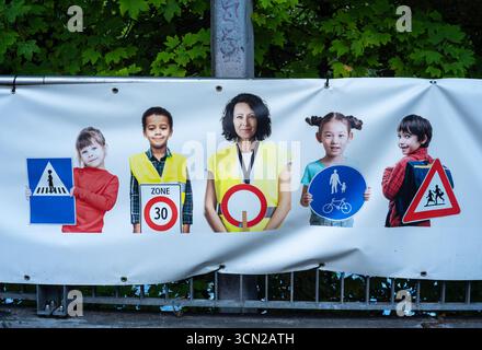 Ginevra, Svizzera - 9 settembre 2025: Uno striscione con le persone che indossano giubbotti di sicurezza, ciascuna tenuta o in piedi accanto a vari segnali stradali, Foto Stock
