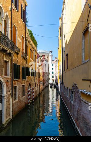 Venezia, Italia, 11 agosto 2025: Colorato canale di Venezia con le gondole lontane Foto Stock