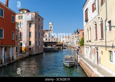Venezia, Italia, 11 agosto 2025: Vista sul canale con barche e chiesa a Venezia Foto Stock