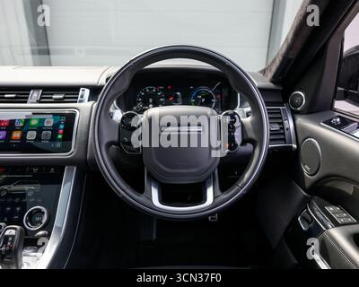 Derby, Regno Unito - 19 settembre 2025: Volante Range Rover, con l'iconico logo Range Rover, pulsanti multifunzione integrati Foto Stock